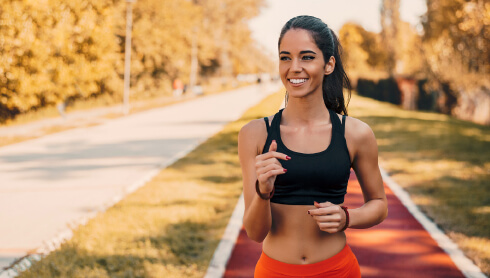 Woman happily jogging on track outside