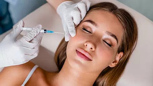 Woman getting botox injection to her cheek